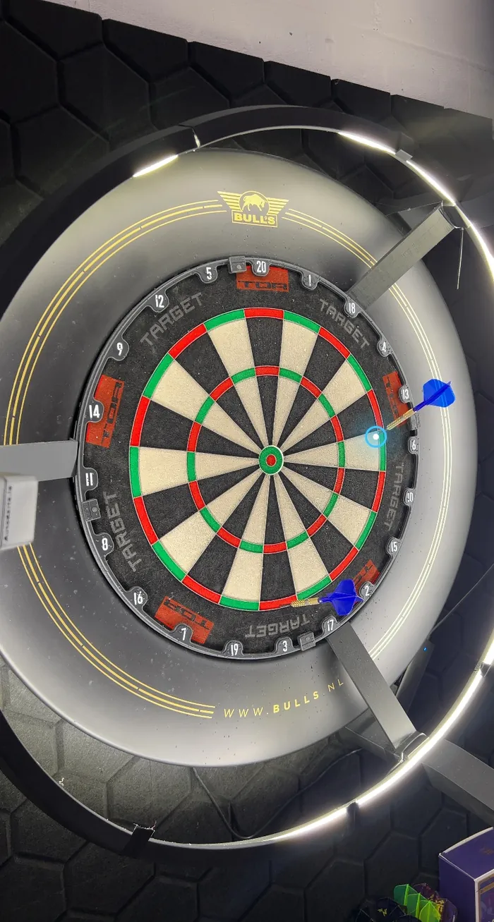 Real photo of a dartboard from an iPhone with the AI's blue marker on a dart